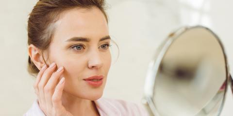 Thomasville Dermatology - Woman looking in mirror at skin|thomasville dermatology rosacea treatment