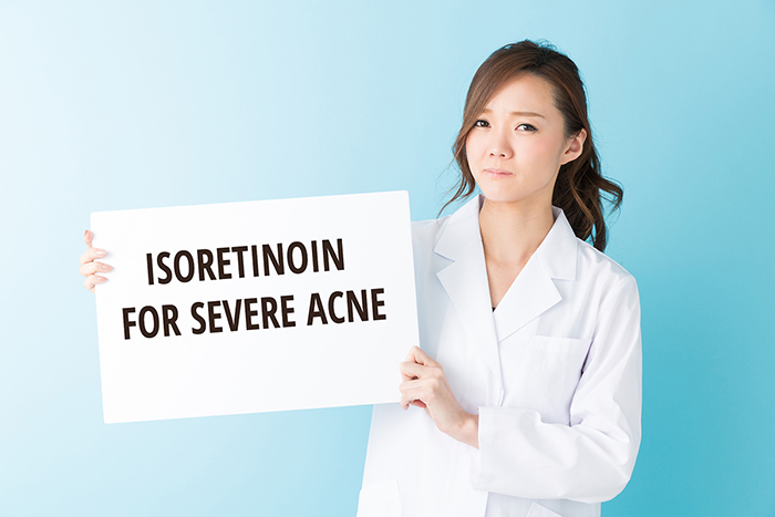 Doctor showing sign with isoretinoin fir severe acne